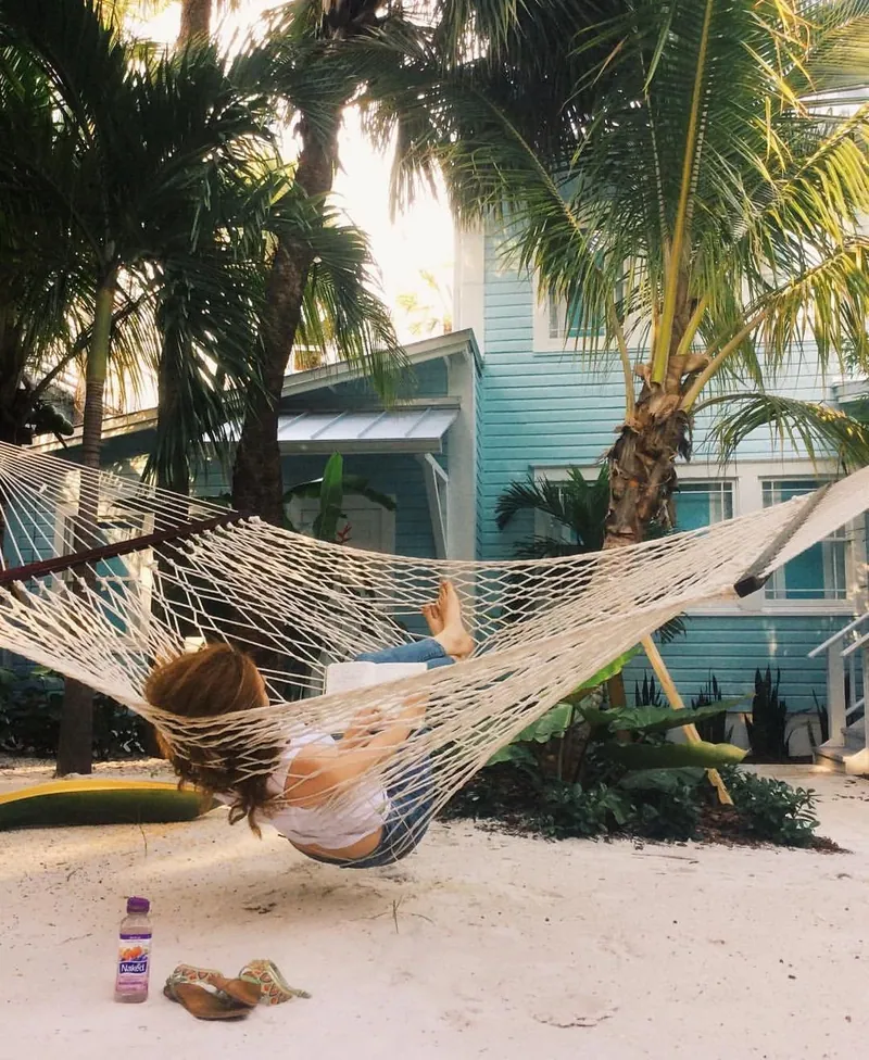 A guest reading in a hammock strung between palms